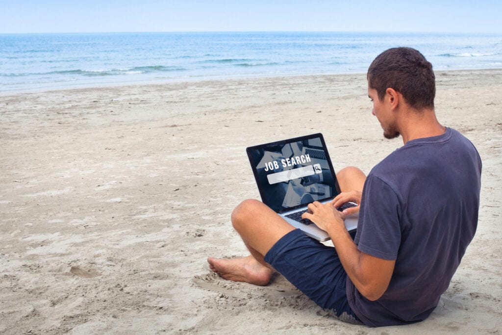 digital nomad working from the beach