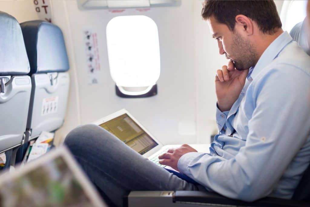 man using laptop during the flight