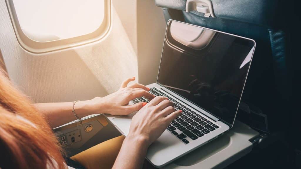 woman working using laptop on a flight