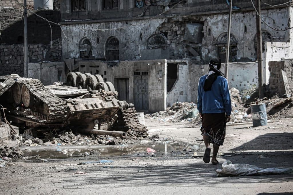 man walking around destroyed streets of yemen