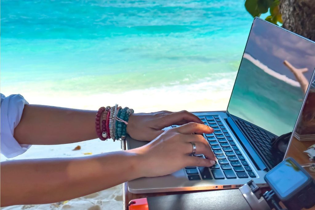 digital nomad working by the beach